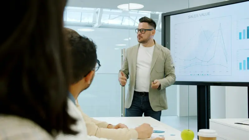 A manager presenting a sales dashboard to his team